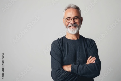 Portrait of smiling mature man standing on white background.