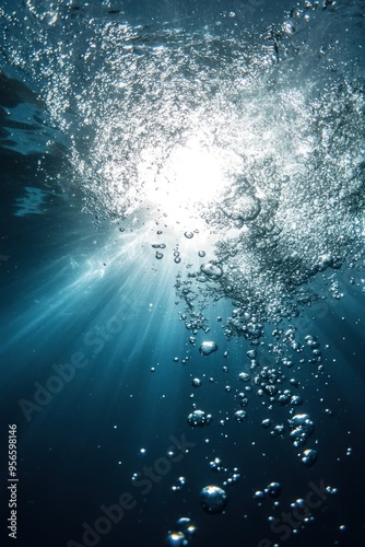 Vivid sun rays pierce the water surface with bubbles