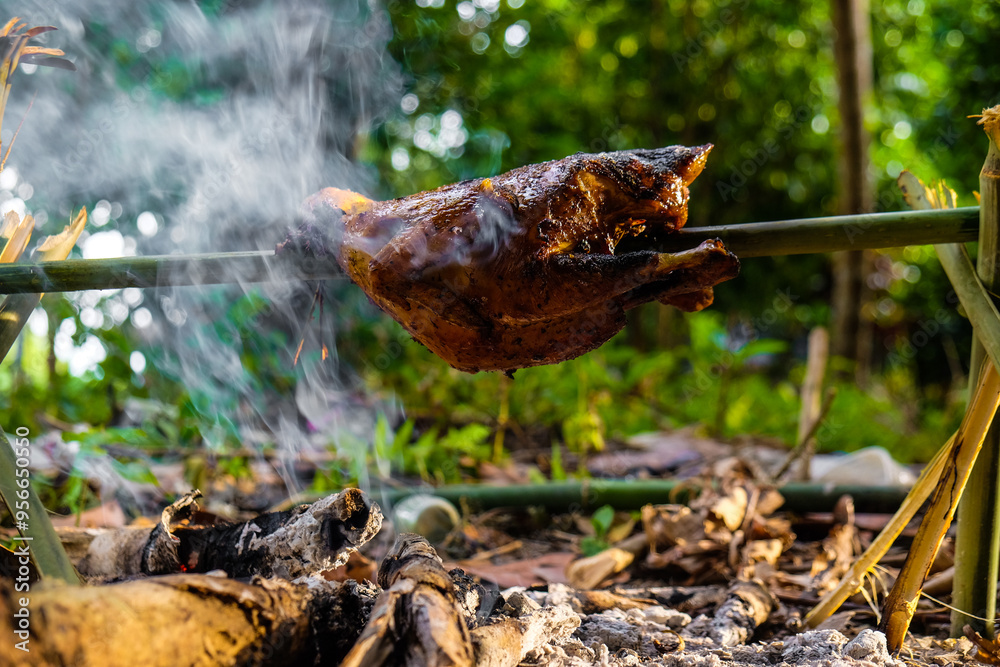 Obraz premium Roasted chicken on fire in camping forest outdoor