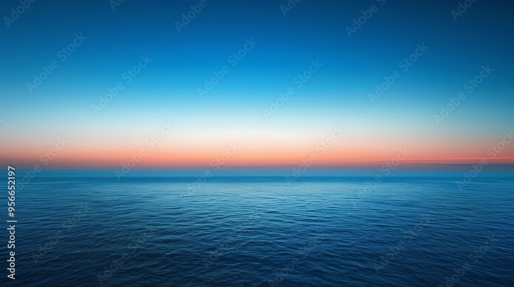Obraz premium A beautiful blue ocean with a pink and blue sunset sky.