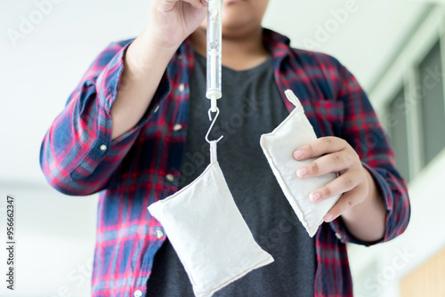 Asian student doing a physics experiment on the weight of objects using a spring balance, concept for science classroom, learning science, science skills and physics learning photo