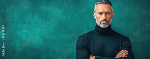 Stoic man standing with arms crossed, a cold phlegmatic expression and intense glare, the scene charged with an underlying aggressive tension photo