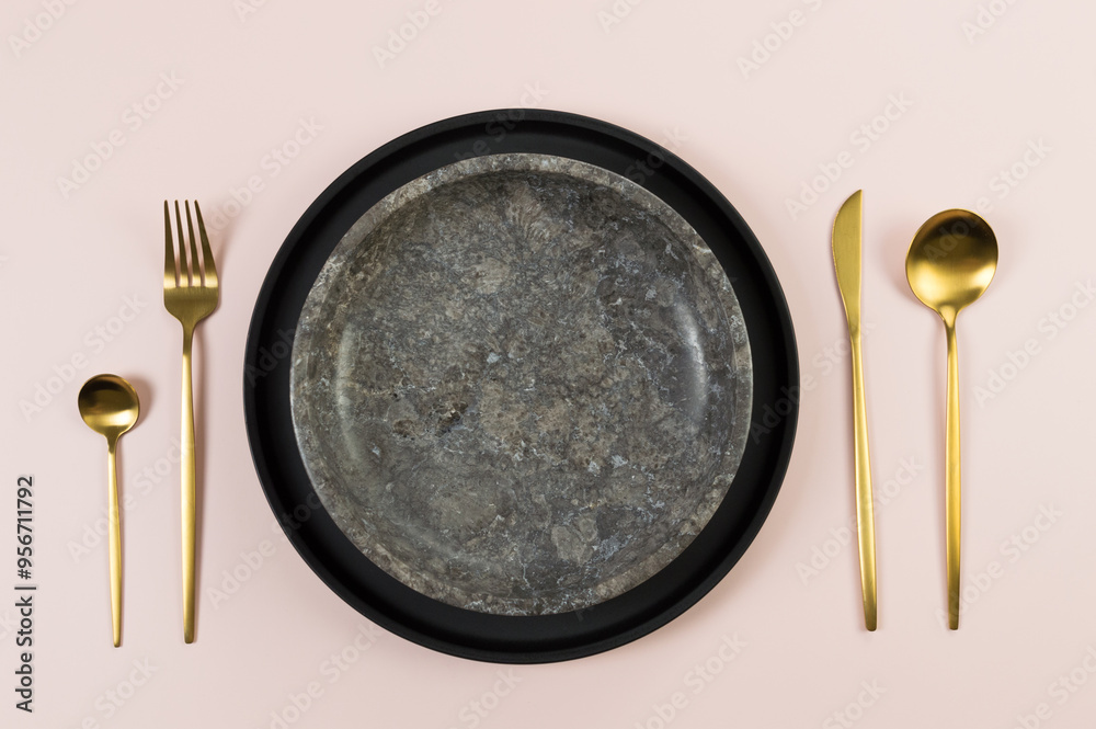 Top view of brown marble plate, black plate, gold cutlery on pink background. Food presentation, stone tray. Table setting, copy space, flat lay. Top view of brown marble plate, black plate, gold cutlery on pink background. Food presentation, stone tray. Table setting, copy space, flat lay.