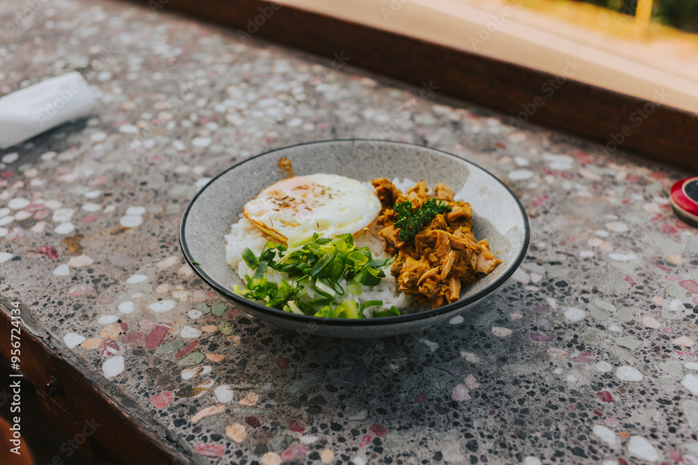 Rice with fried egg and vegetables in a round ceramic plate on the countertop. Asian Lunch Concept Rice with fried egg and vegetables in a round ceramic plate on the countertop. Asian Lunch Concept
