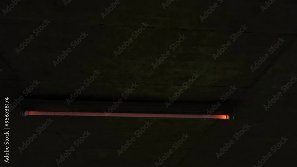 Flickering neon tube in garage with scary malfunction and dysfunction of neon lights flickers glowing and alarming or threatening in halloween atmosphere dramatic darkness gaslight with error switch Flickering neon tube in garage with scary malfunction and dysfunction of neon lights flickers glowing and alarming or threatening in halloween atmosphere dramatic darkness gaslight with error switch
