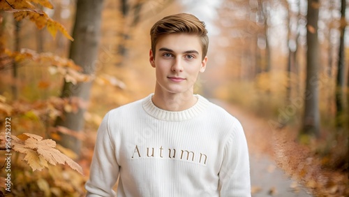 Young man in a white autumn sweater posing in a colorful fall forest