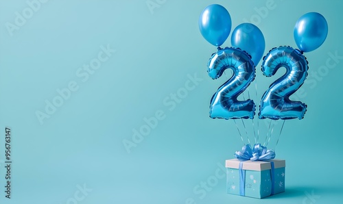 Happy birthday 22th with blue foil balloons and gift box on color background photo