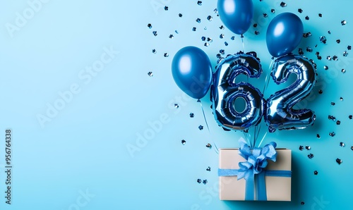 Happy birthday 62th with blue foil balloons and gift box on color background photo