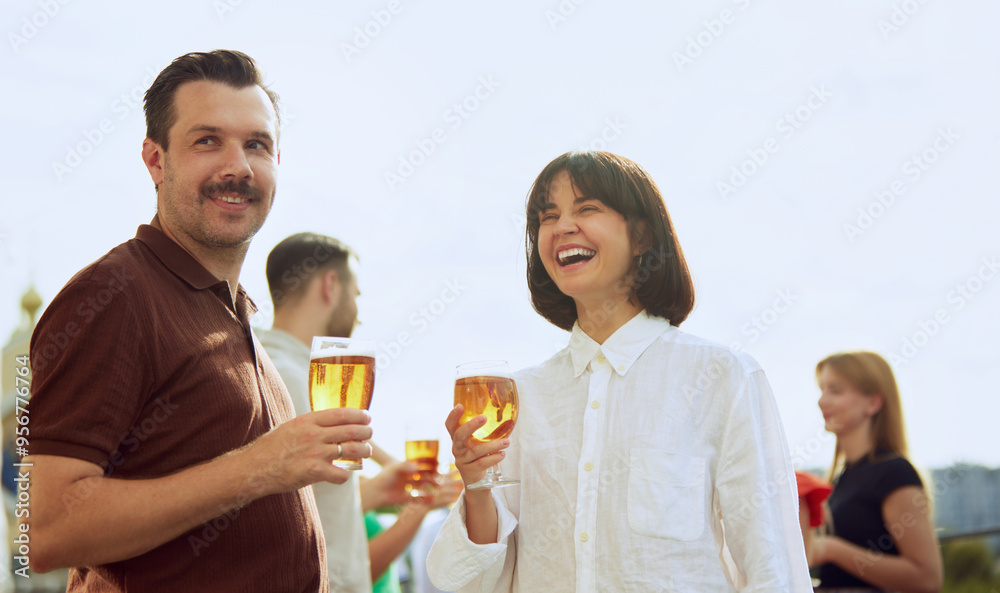 Man and woman enjoy beautiful sunny day, talking and relaxing, drinking beer on sunlit terrace. Festive atmosphere. Concept of Friday mood, celebration, lunch break and Oktoberfest. Man and woman enjoy beautiful sunny day, talking and relaxing, drinking beer on sunlit terrace. Festive atmosphere. Concept of Friday mood, celebration, lunch break and Oktoberfest.
