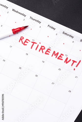 Hand fills in a large wall calendar, counting down the days until retirement, writing 'Retirement'. Concept of early retirement, the Financial Independence, Retire Early movement (FIRE)