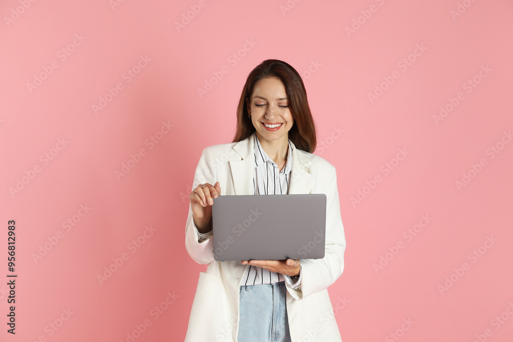 Beautiful woman in stylish white jacket with laptop on pink background Beautiful woman in stylish white jacket with laptop on pink background