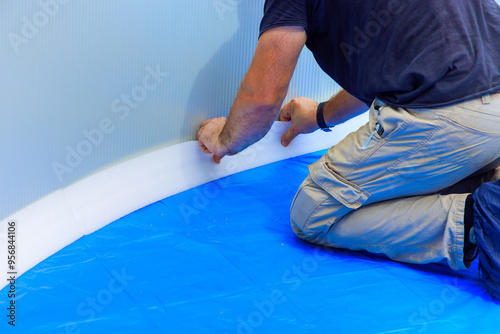 Pool liners are protected by durable foam construction installed by worker in ground pool
