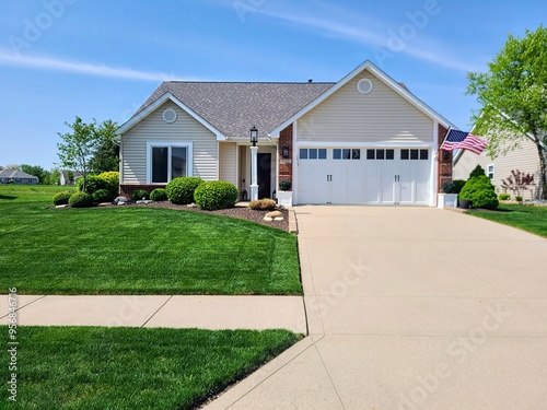 Picturesque Suburban Home with American Flag and Landscaped Yard Front View photo