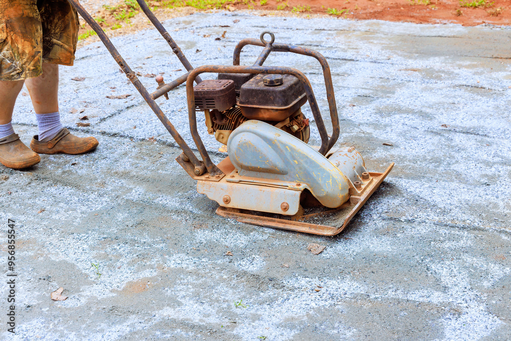 Fototapeta premium Vibratory tamping machine compacting sand during construction of pool platform