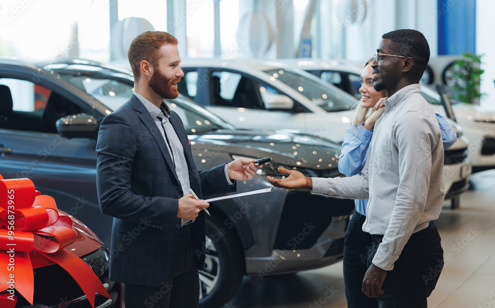 Smiling male seller gives keys to family couple customer, Car showroom business Smiling male seller gives keys to family couple customer, Car showroom business