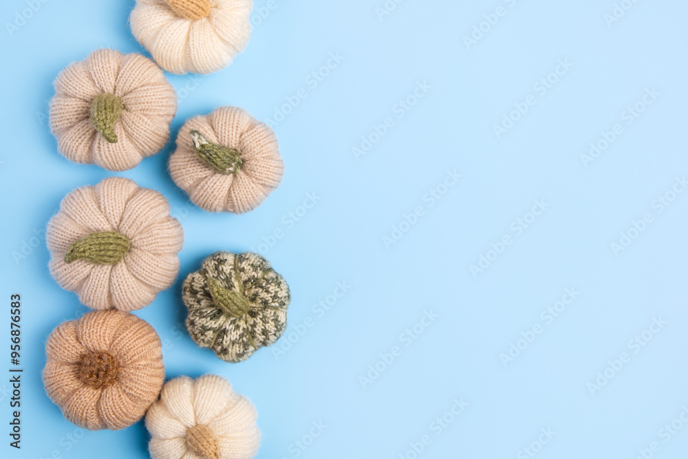 Obraz premium Knitted green, gray and beige pumpkins on blue background with place for text. Concept of autumn, Halloween, Thanksgiving. Handmade work. Flat lay, copy space