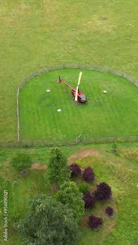 helicopter rotor blades spinning turning props preparing for take off at green grass field heliport photo