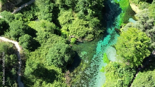 River coast dron bird view in Blue eye river, Albania. Green Seaweed leaves in Turquoise and green water river Bistrice scenic aerial view in Muzine, Finiq, Albania, Europe. photo