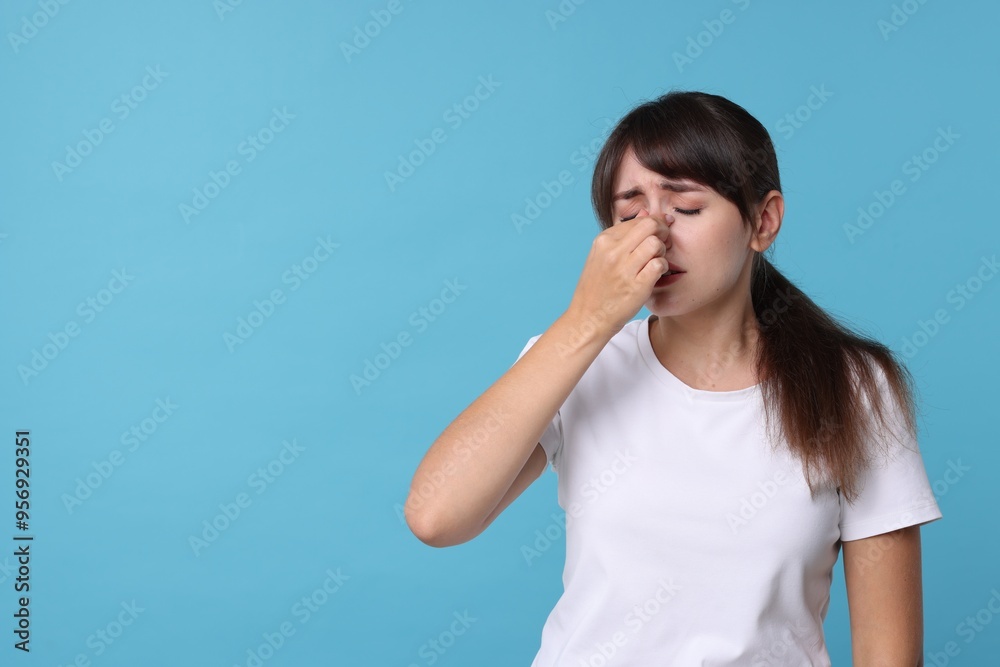 Woman suffering from sinusitis on light blue background. Space for text Woman suffering from sinusitis on light blue background. Space for text