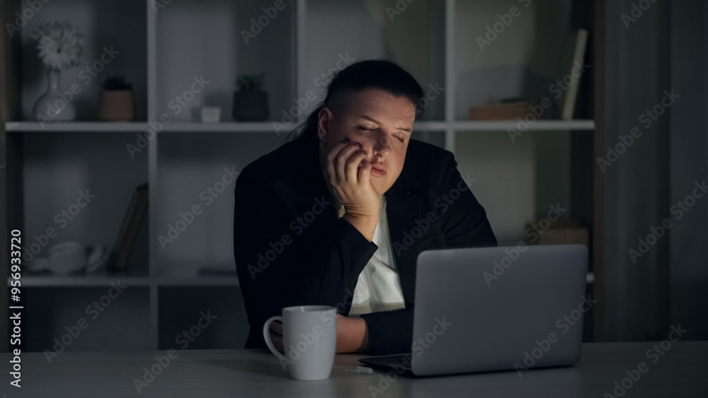 Overworked manager. Night job. Tired unhappy female employee working hard in business finishing task on deadline falling asleep at dark workplace. Overworked manager. Night job. Tired unhappy female employee working hard in business finishing task on deadline falling asleep at dark workplace.