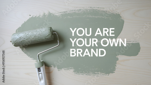 Obraz na płótnie Paint roller with green paint on a wooden surface with the motivational text
