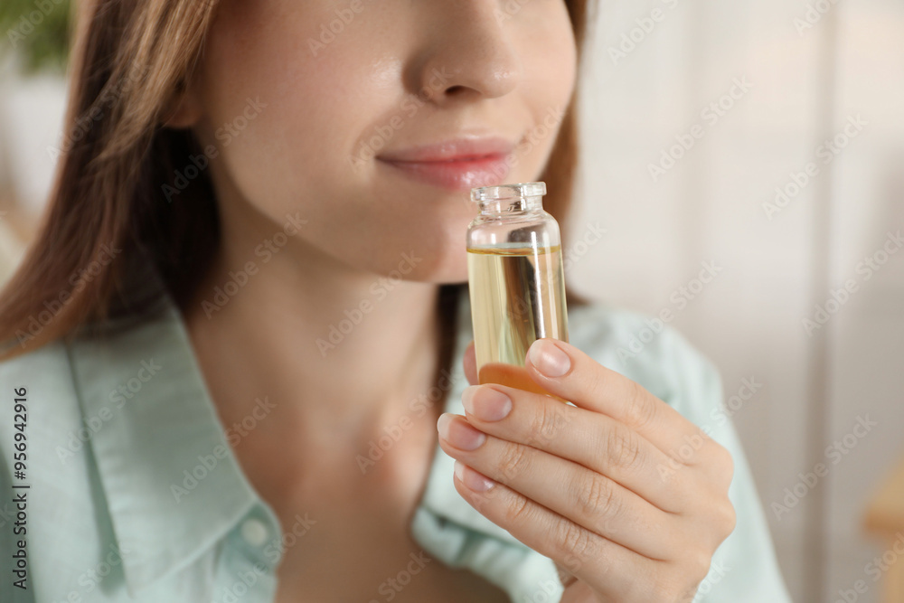 Woman with bottle of essential oil at home, closeup Woman with bottle of essential oil at home, closeup