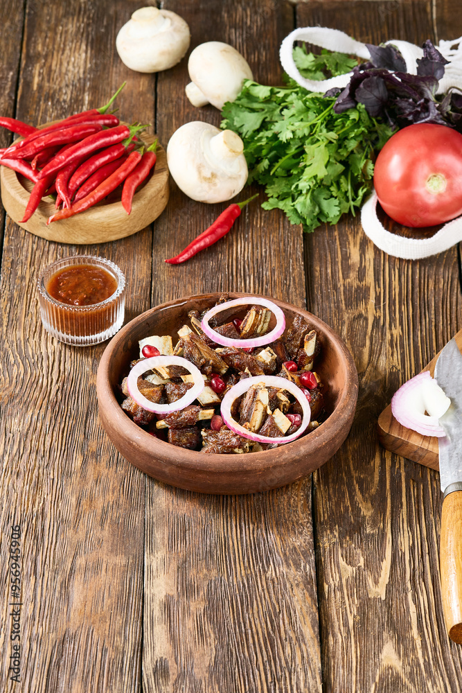Rustic Georgian Chicken Tabaka on Ketsi with Onions and Vegetables on Wooden Background Rustic Georgian Chicken Tabaka on Ketsi with Onions and Vegetables on Wooden Background