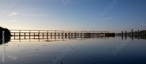 Tranquil Wooden Pier Reflecting in Water at Dusk