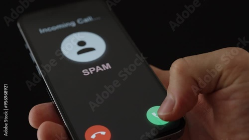 Wallpaper Mural A man chooses to accept or reject a cell phone call marked Spam, from scammers or con artists. Torontodigital.ca