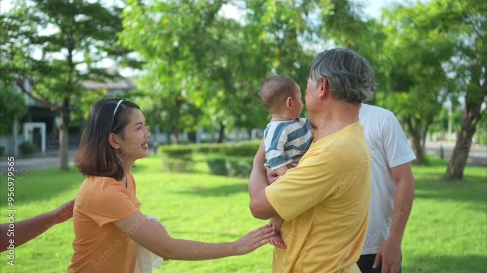 Grandparents and parents with little child are having fun and resting in a park Grandparents and parents with little child are having fun and resting in a park
