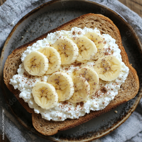 A plate of toast with banana slices and a white cream cheese spread