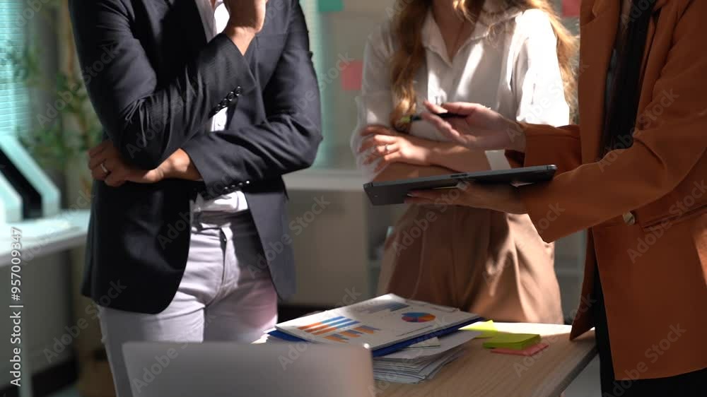 Two asian female ui/ux designers collaborate on a mobile application interface, discussing wireframe designs and sharing ideas in a creative office environment