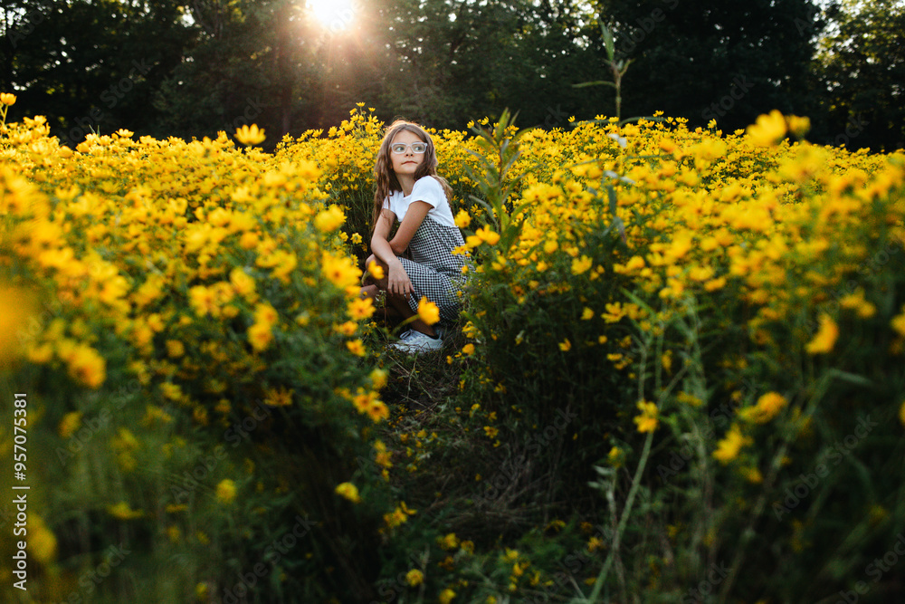 © Maria Manco/Stocksy - Preteen smiles at camera in wildflower field