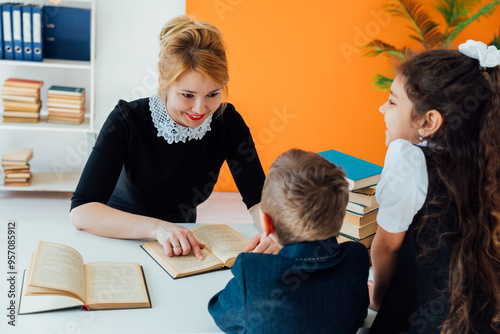 Woman teacher and children schoolchildren in the library with books