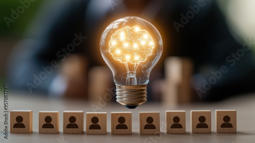 Illuminating Leadership and Teamwork Concept with a Glowing Light Bulb and Wooden Icons of People photo