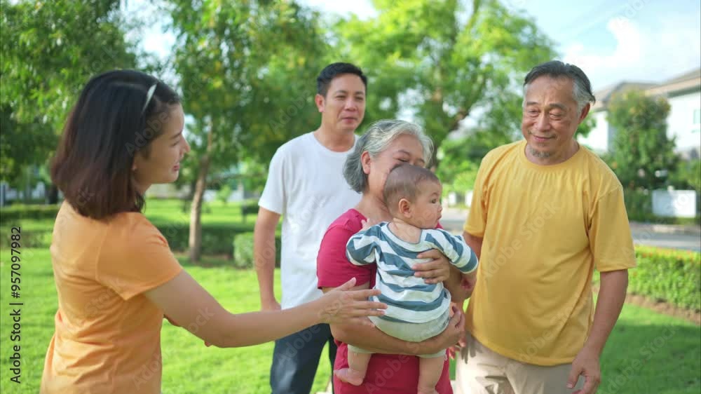 Grandparents and parents with little child are having fun and resting in a park Grandparents and parents with little child are having fun and resting in a park