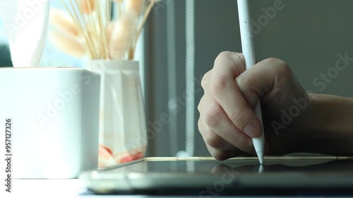 Hand using digital stylus writing on tablet. Concept of digital signature Signing documents electronically via tablet or taking notes electronic