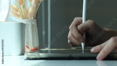 Hand using digital stylus writing on tablet. Concept of digital signature Signing documents electronically via tablet or taking notes electronic