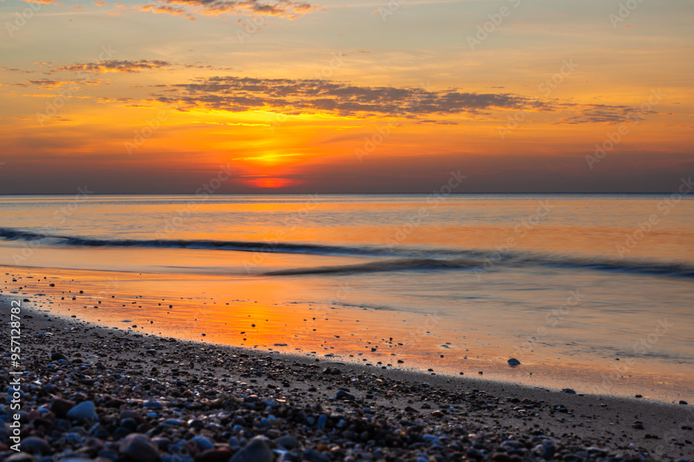 Sandy beach with pebbles of Baltic Sea on Curonian Spit at sunset. Kaliningrad region. Russia