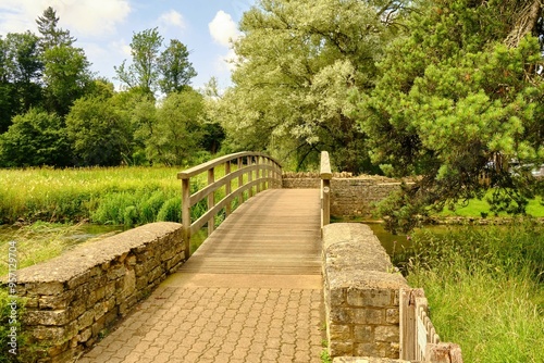 View of a wooden footbridge over the River Coln to the Rack Isle