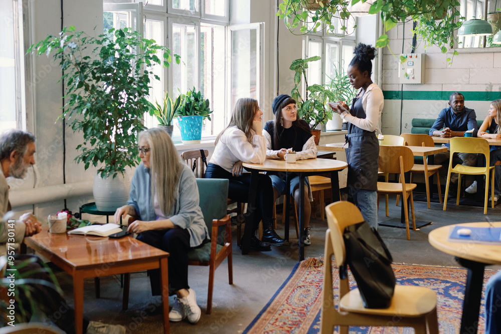 Group of multiracial people resting and spending time together in cafe Group of multiracial people resting and spending time together in cafe