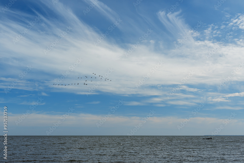 Blue sky with white clouds with the Baltic sea