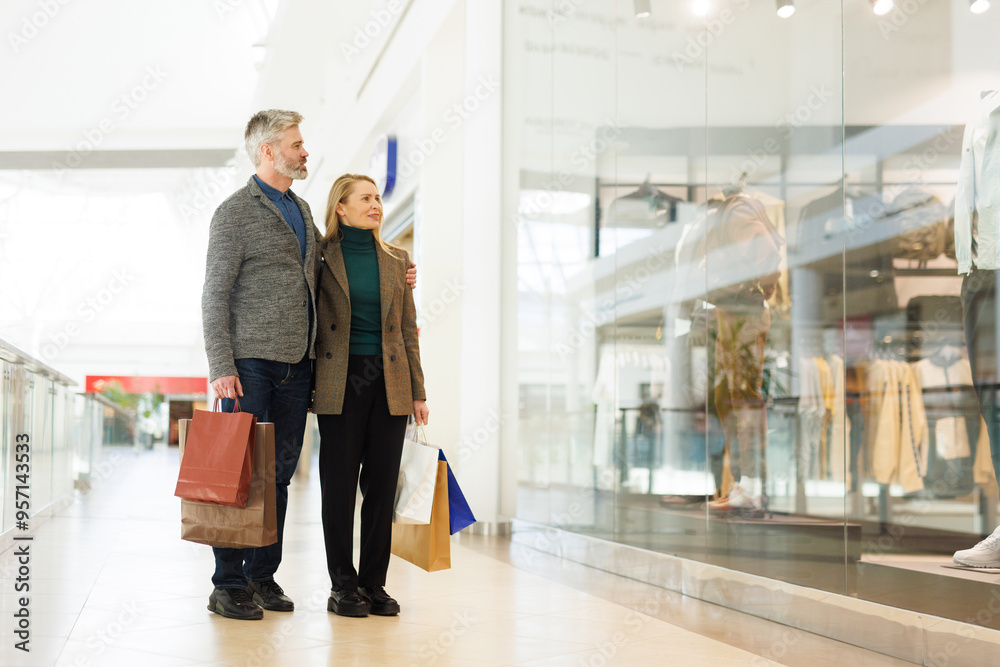 Man hugging woman while they looking at showcase of boutique store Man hugging woman while they looking at showcase of boutique store