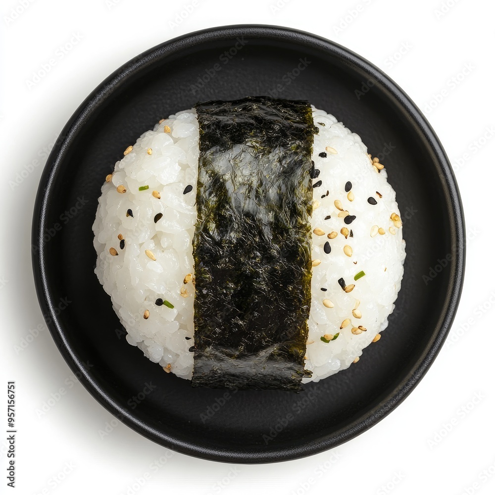 Single Sesame-Topped Onigiri Wrapped in Seaweed on Black Plate Single Sesame-Topped Onigiri Wrapped in Seaweed on Black Plate