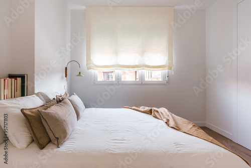 A modern, minimalist bedroom with a neatly made double bed
