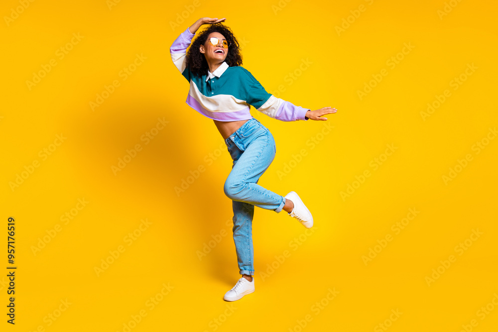 Full size photo of lovely young lady dance enjoy discotheque dressed stylish striped garment isolated on yellow color background Full size photo of lovely young lady dance enjoy discotheque dressed stylish striped garment isolated on yellow color background