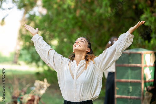 Actress performing in renaissance fair with arms raised