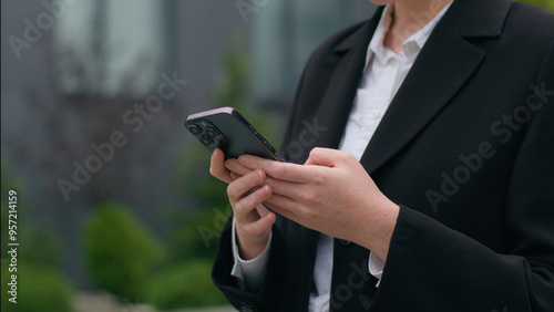 Close up unrecognizable Caucasian businesswoman lady female woman formal suit hands holding modern mobile phone texting working device outdoors city urban street business online chatting social media