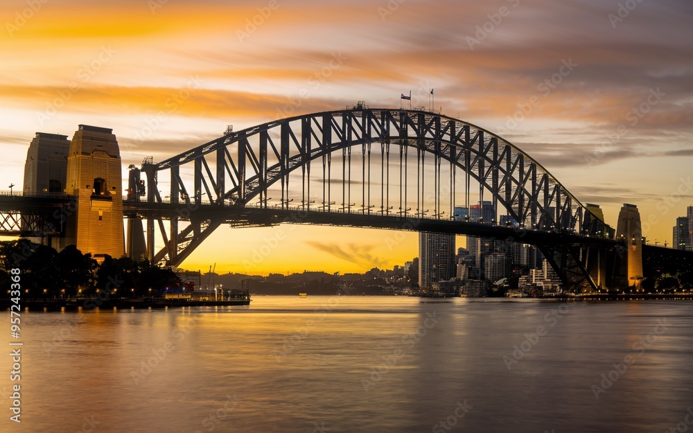 Fototapeta premium Harbour Bridge Sunset Silhouette: Dramatic Sydney Skyline Background