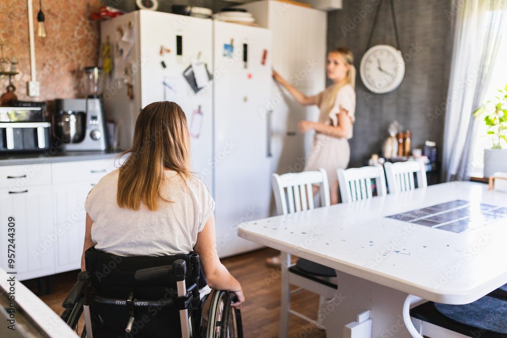 Woman with a Disability Enjoying Lunch with Assistant in Kitchen